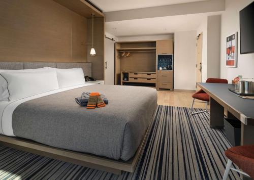 a hotel room with a bed and a desk at Canopy By Hilton Dallas Frisco Station in Frisco