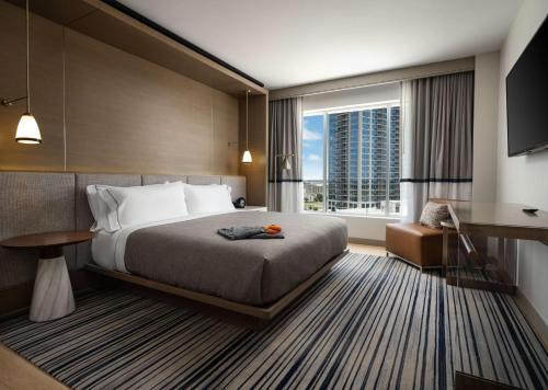 a hotel room with a bed and a large window at Canopy By Hilton Dallas Frisco Station in Frisco