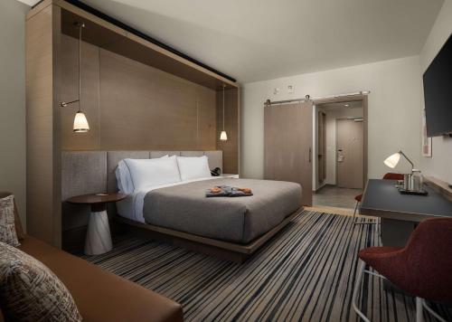 a hotel room with a bed and a desk at Canopy By Hilton Dallas Frisco Station in Frisco