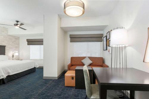 a hotel room with a bed and a couch and a table at Hampton Inn & Suites Denver Tech Center in Centennial