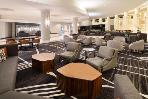 a lobby of a hotel with chairs and tables at Hilton Dallas Lincoln Centre by the Galleria in Dallas