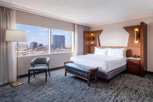 a hotel room with a bed and a large window at Hilton Dallas Lincoln Centre in Dallas