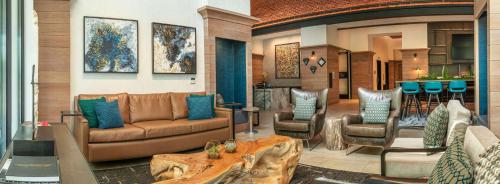 a living room with a couch and two chairs at Canopy By Hilton Dallas Uptown in Dallas