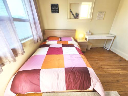 um quarto com uma cama com um cobertor colorido em TORONTO Midtown Spot 3 em Toronto