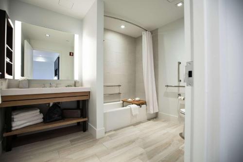 a bathroom with a sink and a tub and a toilet at Canopy By Hilton Dallas Uptown in Dallas
