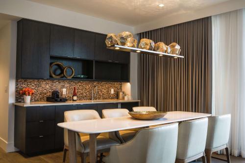 a kitchen with a white table and chairs in a room at Canopy By Hilton Dallas Uptown in Dallas