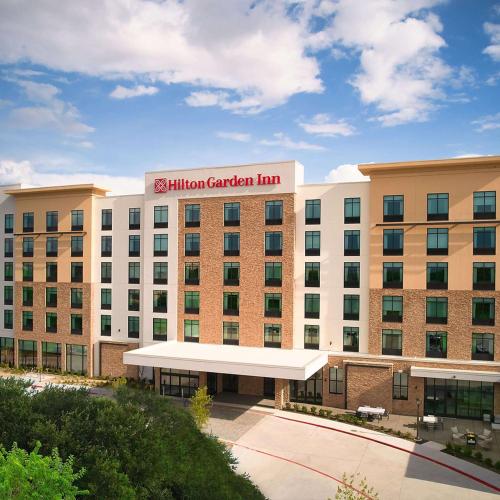 una vista exterior de un edificio de una posada con jardín en Hilton Garden Inn Grapevine At Silverlake Crossing, Tx, en Grapevine