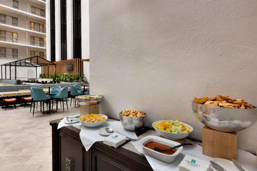 a buffet with bowls of food on a table at Embassy Suites Dallas - DFW International Airport South in Irving