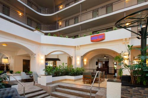 a lobby of a hotel with stairs and plants at Embassy Suites Dallas - DFW International Airport South in Irving