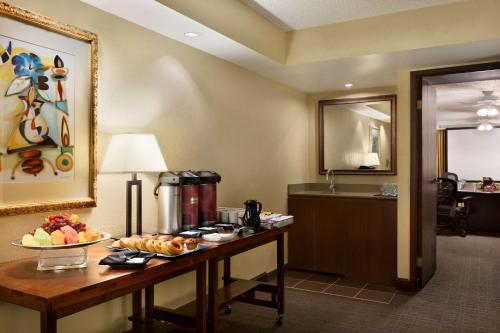 a hotel room with a table with food on it at Embassy Suites Dallas - DFW International Airport South in Irving