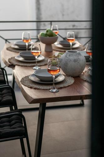 a wooden table with glasses of wine on it at Soleil boutique house with terrace in Rethymno Town