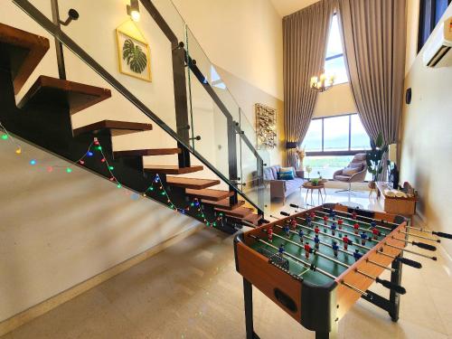 ein Wohnzimmer mit Tischfußball und Treppe in der Unterkunft Loft Suite Seaview Near Johor Bahru Custom 7 pax in Johor Bahru