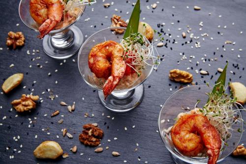 three glasses of food with shrimp in them on a table at Hotel Novum & Spa in Niepołomice