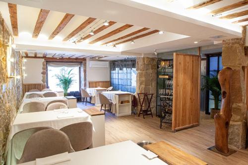 a restaurant with tables and chairs in a room at Hotel El Doncel in Sigüenza