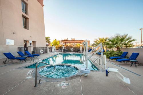 a swimming pool with a slide and blue chairs at Hilton Garden Inn El Paso University in El Paso