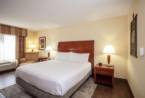 a hotel room with a bed and a chair at Hilton Garden Inn El Paso University in El Paso