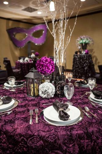 a table with a purple table cloth with plates and silverware at Hilton Garden Inn El Paso University in El Paso