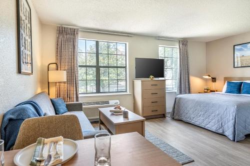 オーランドにあるInTown Suites Extended Stay Select Orlando FL - UCFのベッドとテレビ付きのホテルルーム