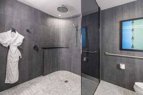 a bathroom with a shower and a toilet at The Statler Dallas, Curio Collection By Hilton in Dallas