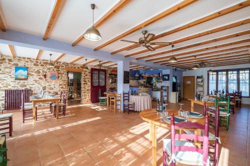 a room with tables and chairs and a stone wall at Pou De Beca Allotjaments i agroturisme in Vall dʼAlba