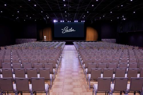 an empty auditorium with chairs and a screen at The Statler Dallas, Curio Collection By Hilton in Dallas