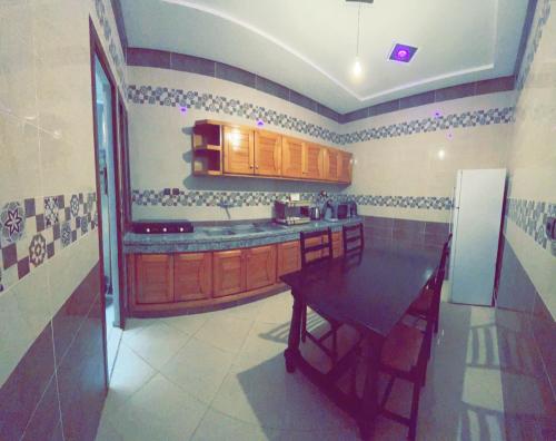 una cucina con tavolo e frigorifero di Dar Al Montazah a Meknès