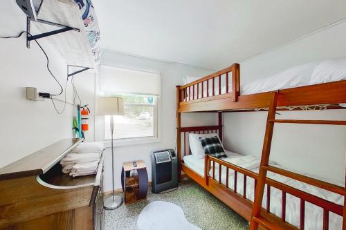 Kleines Zimmer mit 2 Etagenbetten und einem Schreibtisch. in der Unterkunft Blue Jay Cabin in Rhinelander