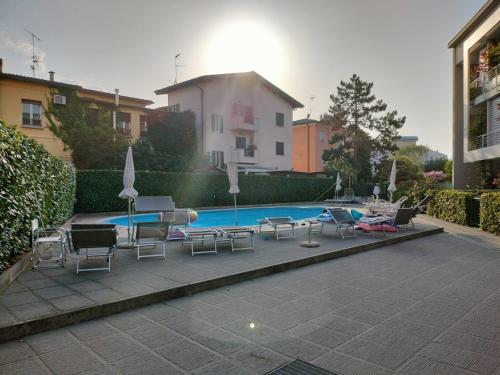 uma piscina com cadeiras e uma mesa e uma piscina em La Darsena apartment em Peschiera del Garda