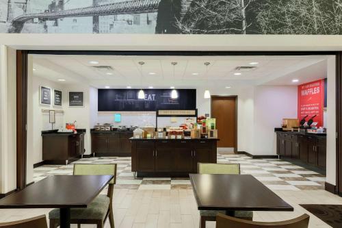 a restaurant with tables and chairs and a counter at Hampton Inn & Suites Wheeling - The Highlands in Triadelphia