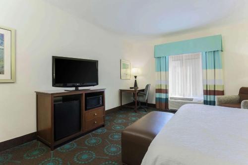 a hotel room with a bed and a flat screen tv at Hampton Inn & Suites Wheeling - The Highlands in Triadelphia