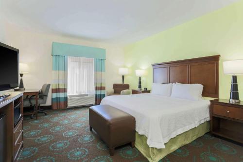 a hotel room with a bed and a flat screen tv at Hampton Inn & Suites Wheeling - The Highlands in Triadelphia