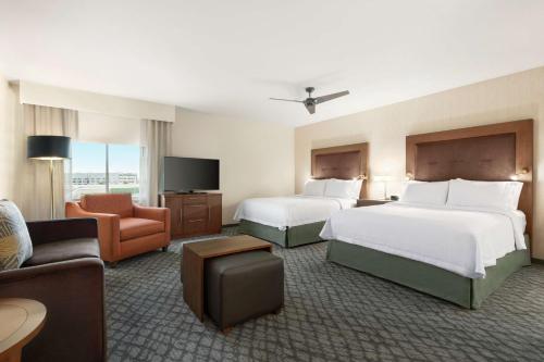 a hotel room with two beds and a couch at Homewood Suites by Hilton Houston NW at Beltway 8 in Houston