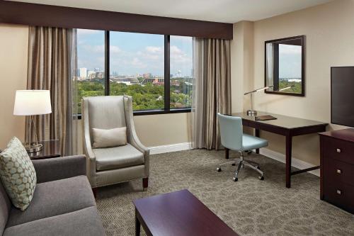 a hotel room with a desk and a chair and a computer at Hilton Houston Plaza/Medical Center in Houston