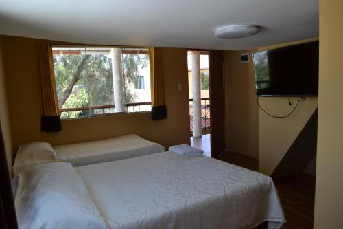 1 dormitorio con cama y ventana grande en La Casona Recoleta, en Arequipa