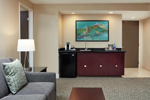 a living room with a couch and a tv at Hilton Houston Plaza/Medical Center in Houston