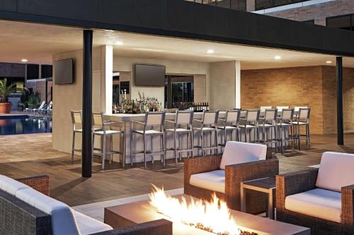 a restaurant with a bar with chairs and fireplaces at Hilton Houston Plaza/Medical Center in Houston