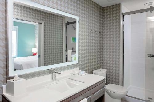 Home2 Suites By Hilton Sugar Land Rosenberg في شوغر لاند: حمام مع حوض ومرحاض ومرآة