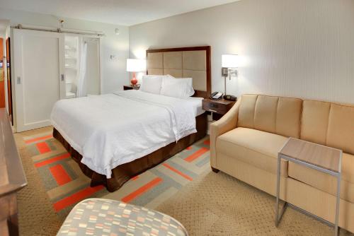 une chambre d'hôtel avec un lit et un canapé dans l'établissement Hampton Inn Harrisonburg - University, à Harrisonburg