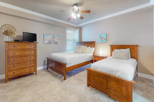 a bedroom with two beds and a ceiling fan at Sans Souci 303 in Pensacola Beach