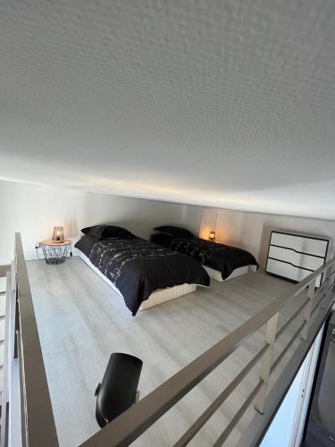 une chambre avec deux lits, un bureau et une chaise dans l'établissement LOFT CANNES Chaleureux - Climatisation - wifi - 650 m du Palais des festivals, plage, à Cannes