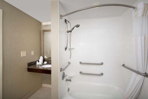 a bathroom with a shower and a tub and a sink at Hilton Garden Inn Huntsville South/Redstone Arsenal in Huntsville