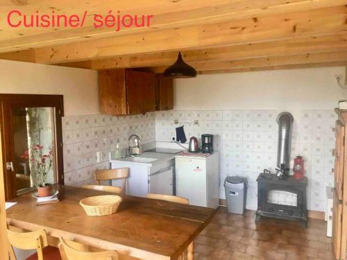 een keuken met een houten tafel en een fornuis bij Chalet accueillant pour des vacances reposantes in Jarrier