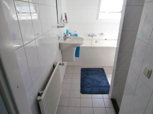 een witte badkamer met een wastafel en een douche bij Medemblik Bed and breakfast in Medemblik