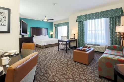 a hotel room with a bed and a living room at Homewood Suites by Hilton Lawton in Lawton