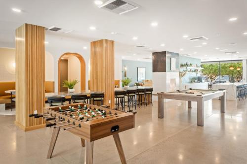 a living room with two tables and billiards at Locale Midtown Phoenix in Phoenix