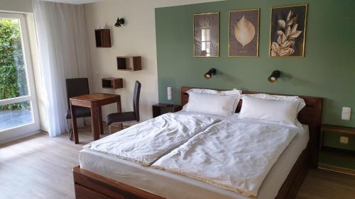 Un dormitorio con una cama y un escritorio y una ventana. en Lillys Garden, en Wutha-Farnroda