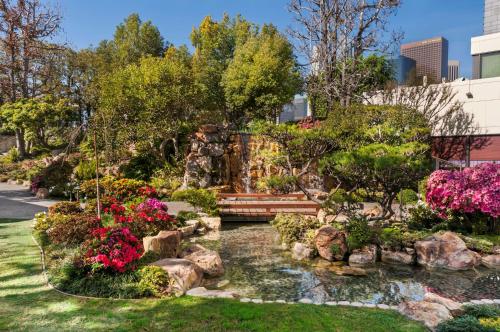 a garden with a pond and flowers at Doubletree by Hilton Los Angeles Downtown in Los Angeles