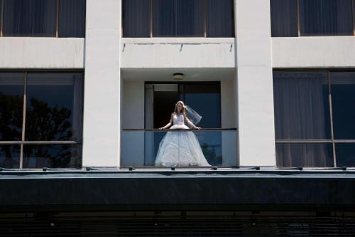 a woman in a wedding dress standing on a balcony at Doubletree by Hilton Los Angeles Downtown in Los Angeles