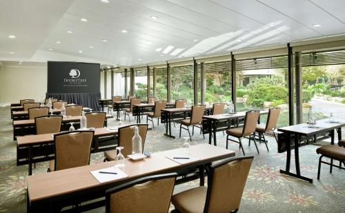 a dining room with tables and chairs and windows at Doubletree by Hilton Los Angeles Downtown in Los Angeles