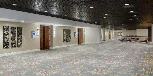 a large room with a carpeted hallway with red chairs at Doubletree by Hilton Los Angeles Downtown in Los Angeles